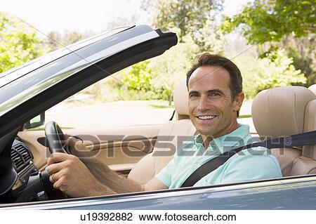 Man in convertible car smiling View Large Photo Image Stock Image - Man in convertible car smiling. Fotosearch