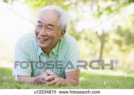 Stock Photography - Man relaxing outdoors smiling. Fotosearch