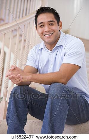 Stock Photo - Man sitting on staircase smiling. Fotosearch