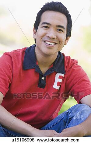 Man sitting outdoors smiling View Large Photo Image Stock Photo - Man sitting outdoors smiling. Fotosearch
