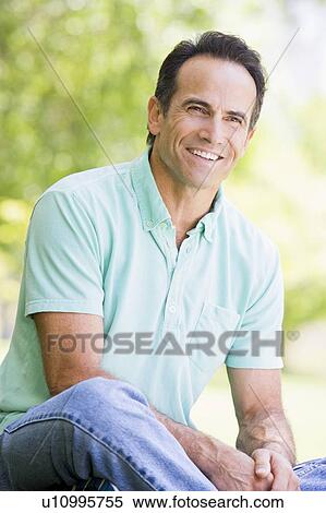 Man sitting outdoors smiling View Large Photo Image Stock Photography - Man sitting outdoors smiling. Fotosearch