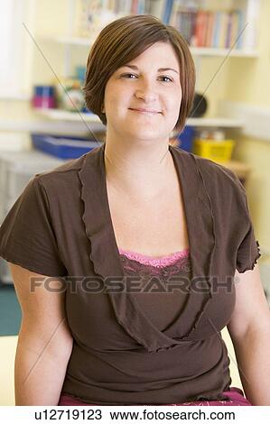 Teacher in class leaning on desk (selective focus) View Large Photo Image Stock Image - Teacher in class leaning on desk (selective focus). Fotosearch