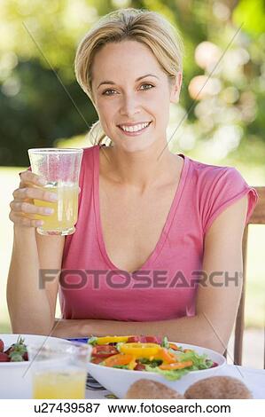 Stock Photo - Woman Enjoying A Salad In A Garden. Fotosearch