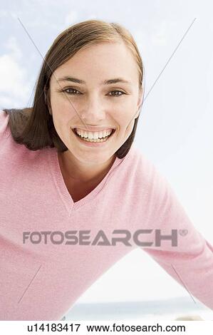 Stock Photo - Woman in a pink sweater posing. Fotosearch