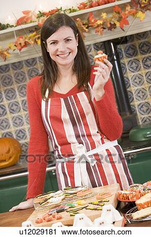 Woman in kitchen making Halloween treats and smiling View Large Photo Image Stock Image - Woman in kitchen making Halloween treats and smiling. Fotosearch