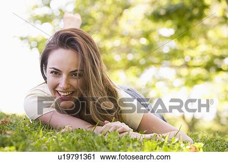 Woman lying outdoors smiling View Large Photo Image Stock Image - Woman lying outdoors smiling. Fotosearch
