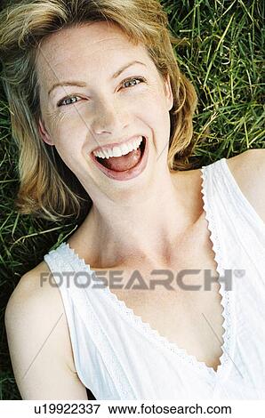 Woman lying outdoors smiling View Large Photo Image Stock Photo - Woman lying outdoors smiling. Fotosearch