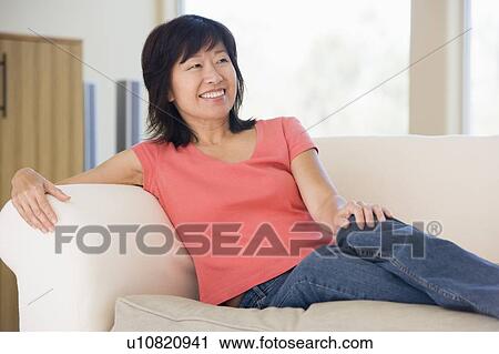 Woman relaxing in living room smiling View Large Photo Image Stock Image - Woman relaxing in living room smiling. Fotosearch