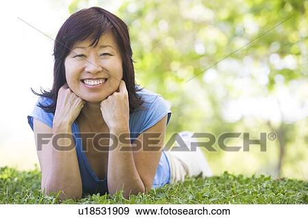Woman relaxing outdoors smiling View Large Photo Image Stock Photo - Woman relaxing outdoors smiling. Fotosearch