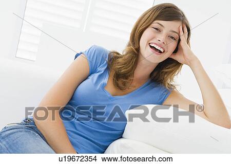 Picture - Woman sitting in living room. Fotosearch
