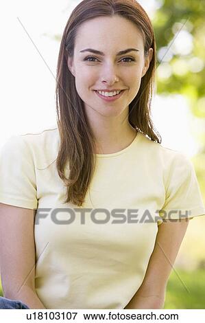 Woman sitting outdoors smiling View Large Photo Image Stock Photo - Woman sitting outdoors smiling. Fotosearch