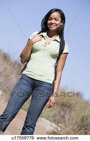 Stock Photo - Woman standing on beach path smiling. Fotosearch