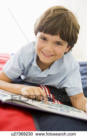 Young Boy Lying Down On His Bed Reading A Book View Large Photo Image Stock Image - Young Boy Lying Down On His Bed Reading A Book. Fotosearch