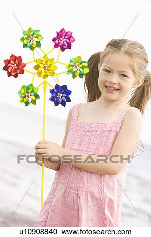 Young girl at beach with toy windmill smiling View Large Photo Image Stock Image - Young girl at beach with toy windmill smiling. Fotosearch