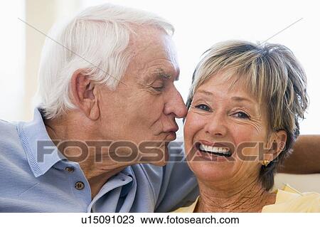 Couple relaxing in living room kissing and smiling View Large Photo Image Stock Image - Couple relaxing in living room kissing and smiling. Fotosearch