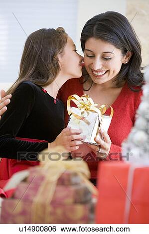 Stock Photograph - Girl Surprising Her Mother With Christmas Gift. Fotosearch