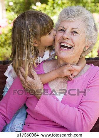 Picture - Grandmother getting a kiss from granddaughter.. Fotosearch