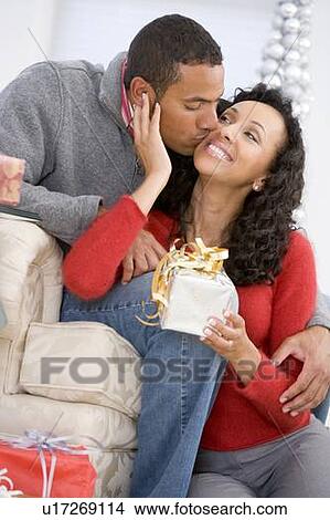 Husband And Wife Affectionately Exchanging Christmas Gifts View Large Photo Image Picture - Husband And Wife Affectionately Exchanging Christmas Gifts. Fotosearch