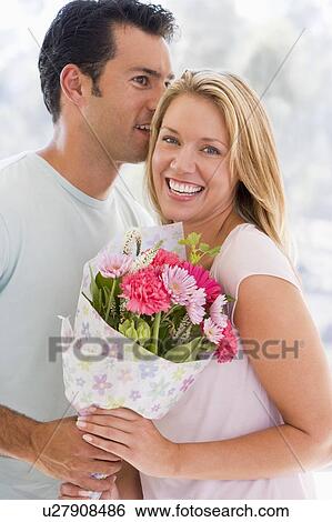 Husband and wife holding flowers and smiling View Large Photo Image Stock Photograph - Husband and wife holding flowers and smiling. Fotosearch