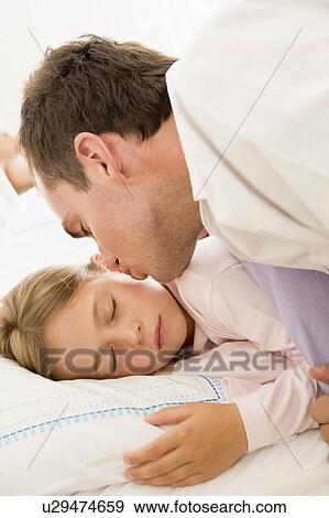 Man waking young girl in bed with kiss View Large Photo Image Stock Photo - Man waking young girl in bed with kiss. Fotosearch