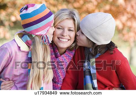 Mother and two young children outdoors in park smiling View Large Photo Image Stock Photo - Mother and two young children outdoors in park smiling. Fotosearch