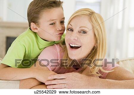 Stock Photo - Young boy kissing smiling woman in living room. Fotosearch