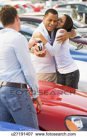 Stock Photo - Young couple shopping for a new car. Fotosearch