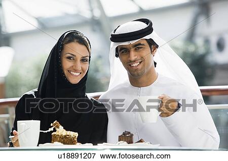 Couple at restaurant eating dessert and smiling (selective focus) View Large Photo Image Stock Photo - Couple at restaurant eating dessert and smiling (selective focus). Fotosearch