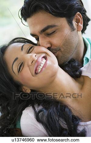 Couple in living room embracing and smiling (high key) View Large Photo Image Stock Image - Couple in living room embracing and smiling (high key). Fotosearch