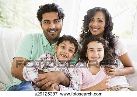 Family in living room sitting on sofa smiling (high key) View Large Photo Image Stock Photo - Family in living room sitting on sofa smiling (high key). Fotosearch
