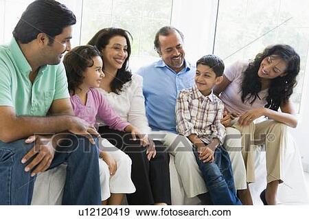 Family sitting in living room smiling (high key) View Large Photo Image Stock Photo - Family sitting in living room smiling (high key). Fotosearch