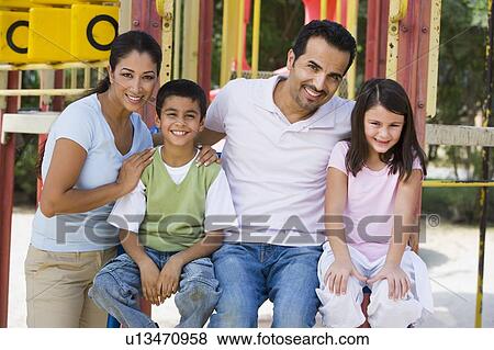 Family sitting on playground structure smiling (selective focus) View Large Photo Image Stock Photo - Family sitting on playground structure smiling (selective focus). Fotosearch