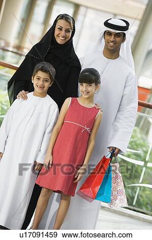 Family standing in mall smiling (selective focus) View Large Photo Image Stock Photo - Family standing in mall smiling (selective focus). Fotosearch