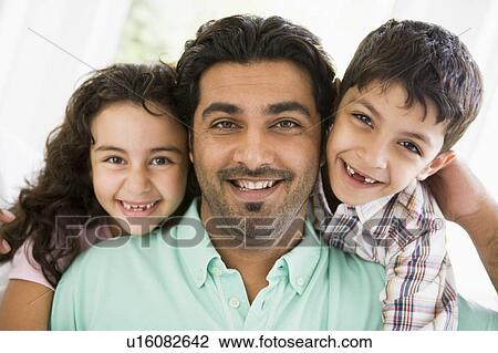 Father and two young children in living room smiling (high key) View Large Photo Image Stock Image - Father and two young children in living room smiling (high key). Fotosearch