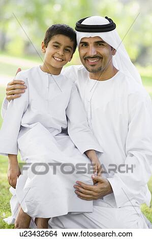 Man and young boy outdoors in a park smiling (selective focus) View Large Photo Image Picture - Man and young boy outdoors in a park smiling (selective focus). Fotosearch