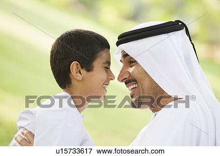 Man and young boy outdoors in park smiling (selective focus) View Large Photo Image Stock Photo - Man and young boy outdoors in park smiling (selective focus). Fotosearch