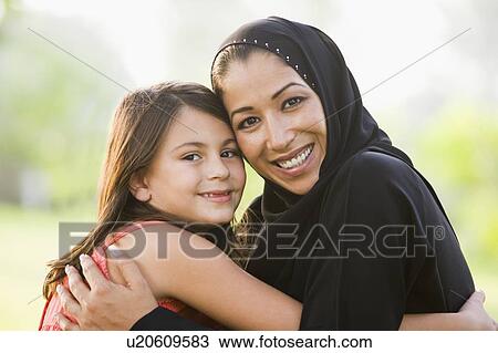 Mother and daughter outdoors in park embracing and smiling (selective focus) View Large Photo Image Stock Image - Mother and daughter outdoors in park embracing and smiling (selective focus). Fotosearch