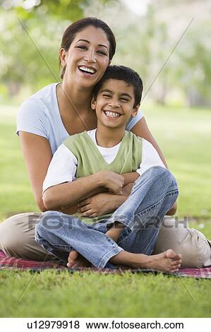 Mother and son outdoors in park bonding and smiling (selective focus) View Large Photo Image Stock Photo - Mother and son outdoors in park bonding and smiling (selective focus). Fotosearch