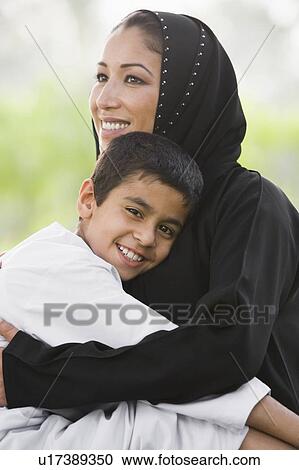 Woman and young boy outdoors in park embracing and smiling (selective focus) View Large Photo Image Stock Image - Woman and young boy outdoors in park embracing and smiling (selective focus). Fotosearch