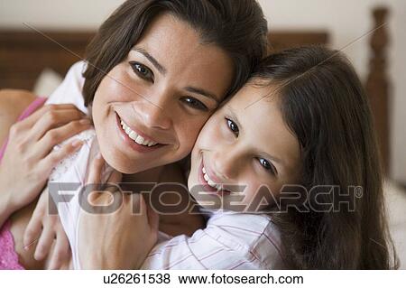 Woman and young girl in bedroom embracing and smiling (selective focus) View Large Photo Image Stock Photo - Woman and young girl in bedroom embracing and smiling (selective focus). Fotosearch