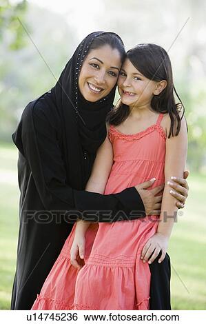 Woman and young girl outdoors in a park smiling (selective focus) View Large Photo Image Stock Photograph - Woman and young girl outdoors in a park smiling (selective focus). Fotosearch