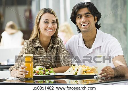 Couple at restaurant eating and smiling (selective focus) View Large Photo Image Stock Image - Couple at restaurant eating and smiling (selective focus). Fotosearch