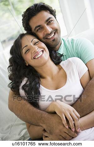 Couple in living room embracing and smiling (high key) View Large Photo Image Stock Photography - Couple in living room embracing and smiling (high key). Fotosearch