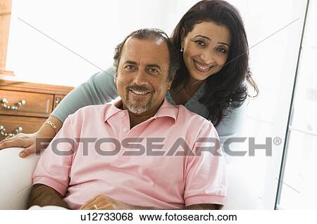 Couple in living room smiling (high key) View Large Photo Image Stock Photo - Couple in living room smiling (high key). Fotosearch