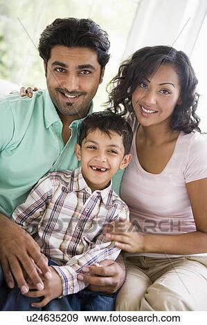 Family in living room sitting on sofa smiling (high key) View Large Photo Image Stock Photo - Family in living room sitting on sofa smiling (high key). Fotosearch