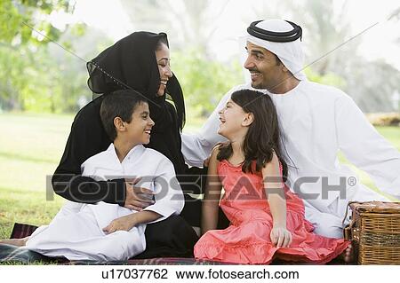 Family outdoors in park having a picnic and smiling (selective focus) View Large Photo Image Stock Image - Family outdoors in park having a picnic and smiling (selective focus). Fotosearch