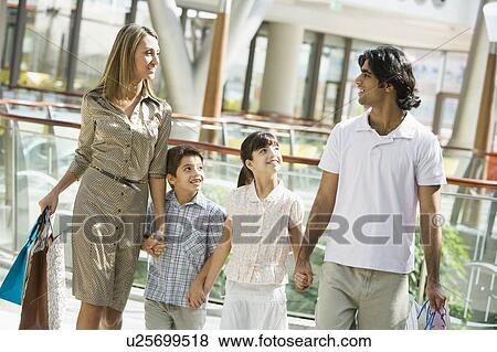 Family walking in mall holding hands and smiling (selective focus) View Large Photo Image Stock Photo - Family walking in mall holding hands and smiling (selective focus). Fotosearch