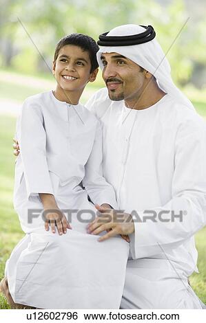 Man and young boy outdoors in a park smiling (selective focus) View Large Photo Image Stock Photograph - Man and young boy outdoors in a park smiling (selective focus). Fotosearch