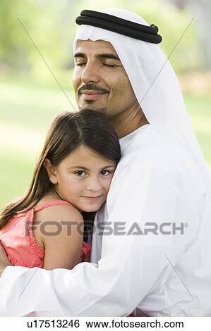 Man and young girl outdoors in park embracing and smiling (selective focus) View Large Photo Image Stock Photograph - Man and young girl outdoors in park embracing and smiling (selective focus). Fotosearch