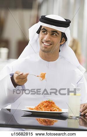 Man at restaurant eating spaghetti and smiling (selective focus) View Large Photo Image Stock Photography - Man at restaurant eating spaghetti and smiling (selective focus). Fotosearch